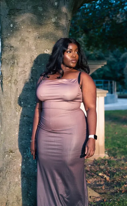 Lifestyle portrait of a woman in a nude dress outdoors, photographed by Imisi Bamiro, Coventry photographer