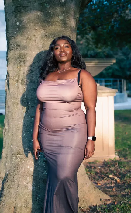 Lifestyle portrait of a woman in a nude dress outdoors, photographed by Imisi Bamiro, Coventry photographer